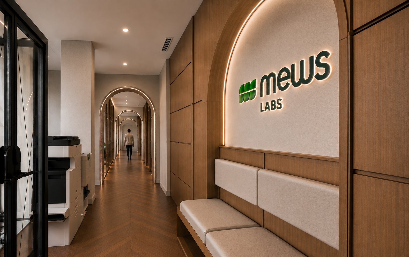 Galerie d'accueil de l'étage : niche en arche rétroéclairée au nom de Mews Labs, banquette, enfilade d'arches